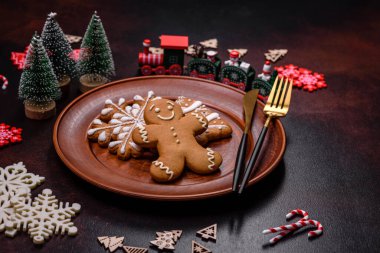 Kahverengi beton arka planda Noel süsleri ve zencefilli çörekler. Festival masası hazırlıyorum.