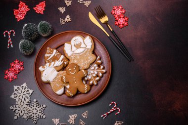 Kahverengi beton arka planda Noel süsleri ve zencefilli çörekler. Festival masası hazırlıyorum.