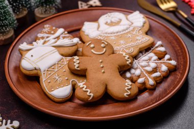 Kahverengi beton arka planda Noel süsleri ve zencefilli çörekler. Festival masası hazırlıyorum.