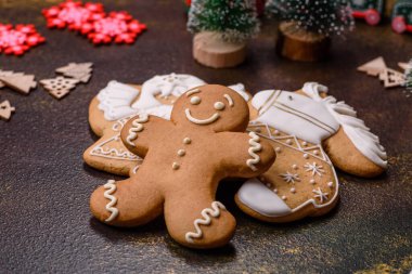 Kahverengi seramik tabakta güzel zencefilli ekmek ve koyu beton arka planda Noel ağacı süslemeleri. Noel için eve hazırlanıyorum.