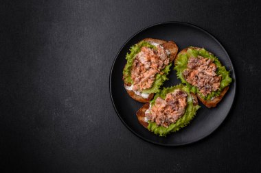 Tost, konserve somon, salata ve bıldırcın yumurtalı lezzetli taze sandviçler.