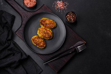 Kabak, havuç ve koyu beton bir masada siyah bir tabakta bulunan bitkilerden alınmış diyet sebze pirzesi. Sağlıklı yemek.