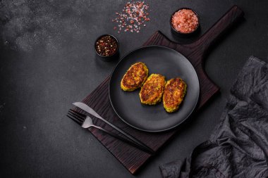 Kabak, havuç ve koyu beton bir masada siyah bir tabakta bulunan bitkilerden alınmış diyet sebze pirzesi. Sağlıklı yemek.