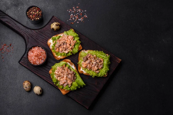 美味的新鲜三明治 带有烤面包 罐头鲑鱼 沙拉和鹌鹑蛋的深色混凝土背景 — 图库照片