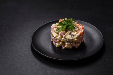 Sosis, yumurta, salatalık, bezelye, havuç ve mayonez ile nefis taze Olivier salatası. Kalorili yemek.