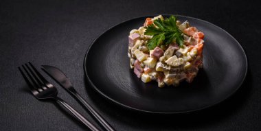 Sosis, yumurta, salatalık, bezelye, havuç ve mayonez ile nefis taze Olivier salatası. Kalorili yemek.