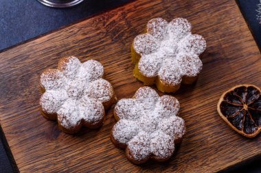 Bir dilim portakallı sıcak şarap, tarçın, karanfil ve diğer baharatlarla çikolatalı kekler ve koyu beton arka planda Noel süslemeleri.