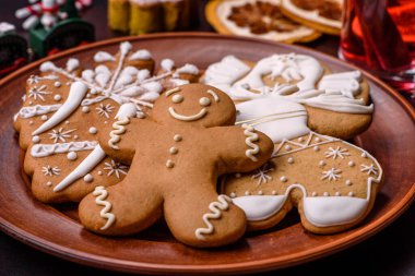 Bir dilim portakallı sıcak şarap, tarçın, karanfil ve diğer baharatlarla çikolatalı kekler ve koyu beton arka planda Noel süslemeleri.