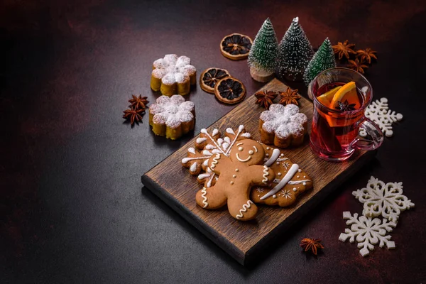 用一片橙子 丁香和其他香料 巧克力松饼和圣诞装饰品装饰在黑暗的混凝土背景下的热覆膜葡萄酒 — 图库照片