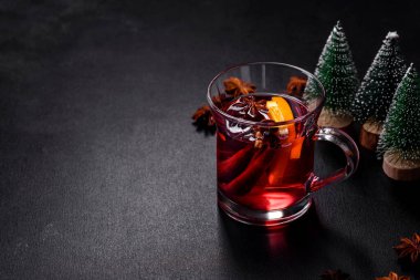 Noel, beton bir masada baharatlı ve meyveli kırmızı şarap pişirdi. Geleneksel sıcak içecek Noel zamanı