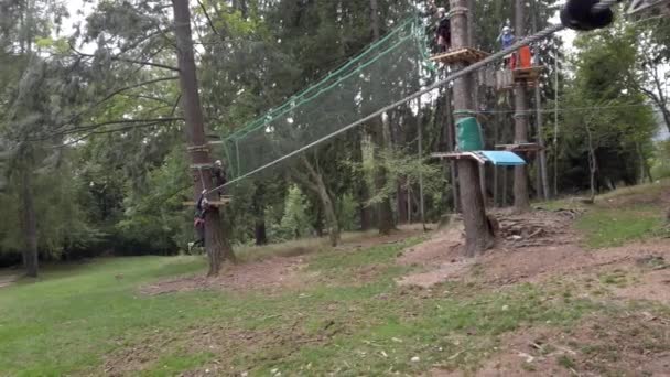 오르는 나무가 공원에서 투구와 굴착기로 밧줄의 균형을 시험을 통과하는 이탈리아 — 비디오