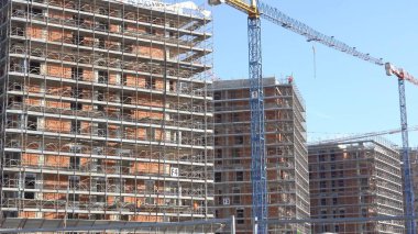 İnşaat vinci ve mavi gökyüzünün altındaki binalar