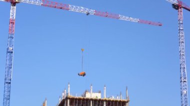 İnşaat vinci ve mavi gökyüzünün altındaki binalar