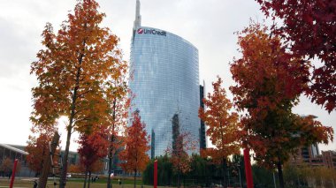 Avrupa, İtalya, Milano Kasım 2021 - Porta Nuova şehir merkezinde sonbahar - ağaçlarda kırmızı yapraklar Unicredit kulesi ekolojik gökdelen