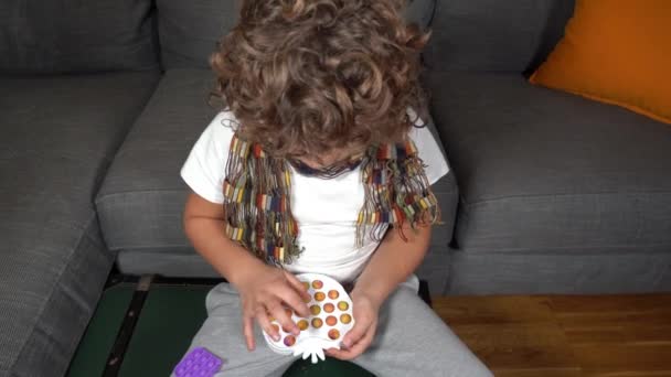 子供のためのそれゲームをポップ 子供の手はカラフルな抗ストレスプラスチックペレットを絞ることによって彼らの指で遊ぶ — ストック動画