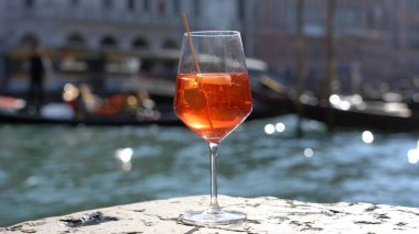 Kız el ele tutuşup aşk şehrinde bir bardak Spritz içiyor - aperatif, alkollü içecek Spritz Camapari ya da Aperol - Venedik 'in tipik içeceği beyaz şaraptan, portakallı - Rialto Köprüsü 