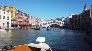 Avrupa, İtalya, Venedik Kasım 2021 - Büyük Kanal 'daki tekne ünlü Rialto köprüsünün altından geçiyor, aşk şehirlerinin turistik cazibesi - köprü üzerinde turizm ve gölde gondollar