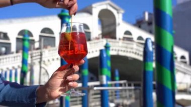 Kız el ele tutuşup aşk şehrinde bir bardak Spritz içer. Aperatif, alkollü içecek Spritz Campari ya da Aperol. Venedik 'in tipik beyaz şarap, portakal suyu.
