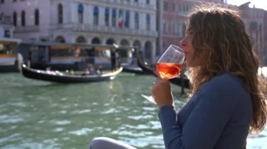 Kız el ele tutuşup aşk şehrinde bir bardak Spritz içer. Aperatif, alkollü içecek Spritz Campari ya da Aperol. Venedik 'in tipik beyaz şarap, portakal suyu.