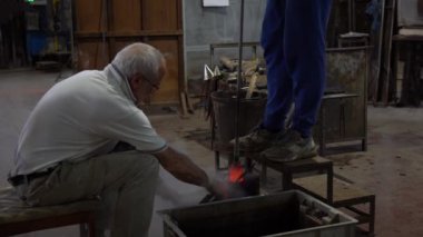 Murano, Venedik, İtalya Kasım 2021: Murano 'da ünlü Venedik camı yapmak, Venedik' teki fabrikada cam yapımı - atölye çalışması elle yapılıyor ve cam kırılıyor