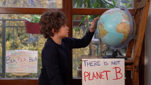 イタリア ミラノ 活動家の少年記号で7歳の子供 コンセプト地球を救う 緑に行く 未来の若者のための金曜日4気候 Covid 19コロナウイルスのロックダウン中に家にいる少年 惑星Bなし — ストック動画