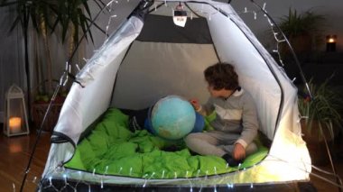 Avrupa, İtalya, Milano - Covid-19 Coronavirus tecridi sırasında evdeki çocuk bir kamp evinde oturuyor - seyahat etme arzusu