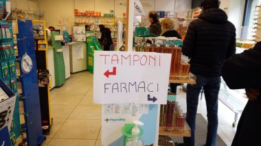 Avrupa, İtalya, Milano Aralık 2021 - Covid-19 Coronavirus salgınına karşı hızlı bir test örneği almak için eczanenin önünde kuyruk oluşturan insanlar, enfeksiyonlarda artış kaydetti.