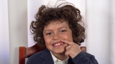 Yedi yaşında bir çocuk süt dişlerinin döküldüğünü ve azı dişlerinin büyüdüğünü gösteriyor. Çocuklar için sağlık ve sağlıklı diş bakımı. Diş dökülmesi kavramı. 