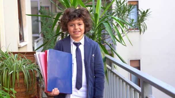 7歳の少年は制服を着た小学生の学校に行く準備をしている 笑顔の学生 本を持った子供 学校に戻る 学校の時間 教育の概念 — ストック動画