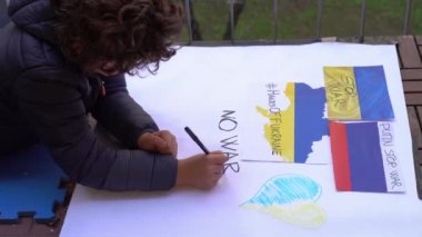 7 yaşındaki bir çocuk, Rusya ile Ukrayna arasındaki savaşı işaret levhası ile protesto etti. Savaşı ve el fenerini durdurdu. Avrupa 'da NATO' ya yakın bölgelerde çatışmalar başladı.