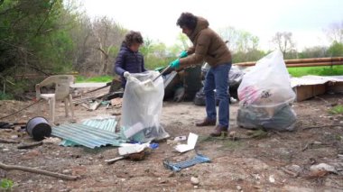 Avrupa, Baba ve 7 yaşındaki çocuk doğadaki kirletici atıkları topluyorlar. Çevreyi temizlemek ve Dünya gezegenini iklim değişikliği ve küresel ısınmadan kurtarmak - eğitim ve doğa