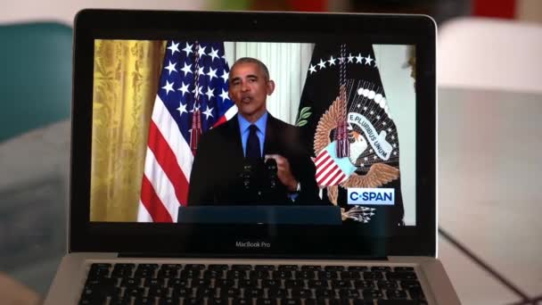 ヨーロッパ ミラノ2022年4月 コンピュータ上のウクライナとロシアの戦争に関するテレビニュースを見る バラク オバマ第44米国大統領が話す — ストック動画
