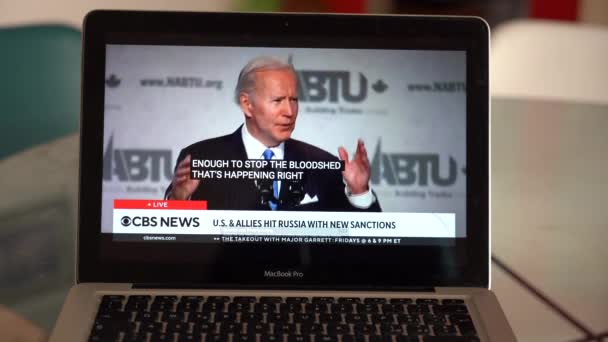 ヨーロッパ ミラノ2022年4月 コンピュータ上のウクライナとロシアの戦争に関するテレビニュースを見る Joe Biden46Th 大統領が語る — ストック動画