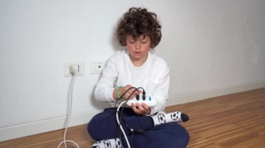 Evde 7 yaşında bir çocuk elektrik prizini kullanıyor ve onunla oynuyor. Çocukluğunda şok olma tehlikesi var.