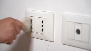 7 yaşındaki çocuk evde elektrik soketi kullanıyor ve onunla oynuyor. Şok olma tehlikesi var. Çocukluğunda ev hayatı.