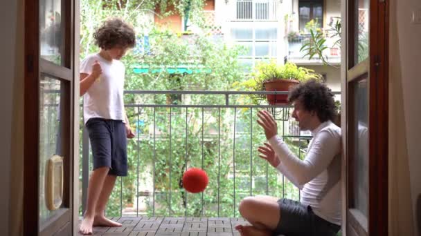 父親と7歳の息子は 夏の準備ができて春の到来と一緒に自宅でサッカーをします 関係とスポーツ活動屋内 — ストック動画