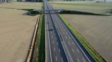 Taşra manzarası ve trafik otobanında yüksek voltajlı elektriğin geçişi için yeni bir elektrik direğinin insansız hava aracının görüntüsü - elektrik enerjisi ve yeşil devrimin maliyetinde artış