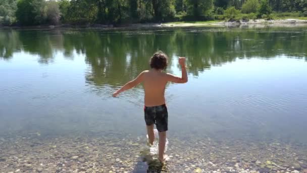 7歳の男の子は夏の到着と水の中でジャンプし 学校のレッスンを終了し 休日を開始します — ストック動画