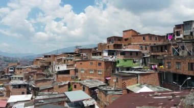 Medellin, Kolombiya, Comuna 13 gecekondu bölgesinin insansız hava aracı görüntüsü. Bir zamanlar dünyanın en tehlikeli mahallelerinden biri olan Favela evleri ve şehir merkezindeki modern gökyüzü.