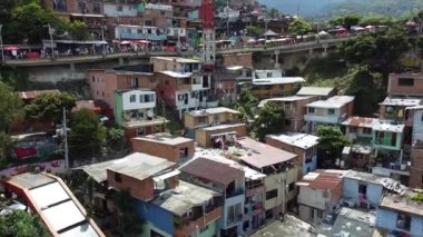 Medellin, Kolombiya, Comuna 13 gecekondu bölgesinin insansız hava aracı görüntüsü. Bir zamanlar dünyanın en tehlikeli mahallelerinden biri olan Favela evleri ve şehir merkezindeki modern gökyüzü.