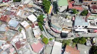 Medellin, Kolombiya, Comuna 13 gecekondu bölgesinin insansız hava aracı görüntüsü. Bir zamanlar dünyanın en tehlikeli mahallelerinden biri olan Favela evleri ve şehir merkezindeki modern gökyüzü.