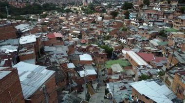 Medellin, Kolombiya, Comuna 13 gecekondu bölgesinin insansız hava aracı görüntüsü. Bir zamanlar dünyanın en tehlikeli mahallelerinden biri olan Favela evleri ve şehir merkezindeki modern gökyüzü.