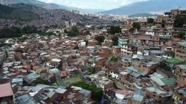 Medellin, Kolombiya, Comuna 13 gecekondu bölgesinin insansız hava aracı görüntüsü. Bir zamanlar dünyanın en tehlikeli mahallelerinden biri olan Favela evleri ve şehir merkezindeki modern gökyüzü.