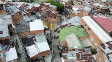 Medellin, Kolombiya, Comuna 13 gecekondu bölgesinin insansız hava aracı görüntüsü. Bir zamanlar dünyanın en tehlikeli mahallelerinden biri olan Favela evleri ve şehir merkezindeki modern gökyüzü.
