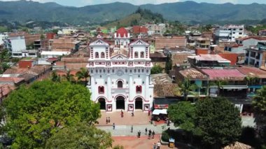 Güney Amerika, Kolombiya, Guatape 'in Medellin yakınlarındaki küçük bir sömürge köyündeki kilise katedralinin insansız hava aracı görüntüsü, Antioquia turistik merkezi. 