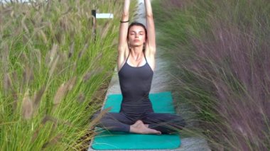 21 yaşındaki kız, doğal botanik bahçesinde yoga jimnastik yapıyor. Milano şehrinde rahatlama ve meditasyon. Şehir yaşamının çabukluğu ve çabasıyla fiziksel ve zihinsel egzersizlerle mücadele ediyor.