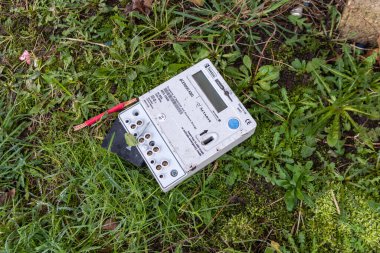 A Talexus pre-payment electricity key meter lying on grass after being uninstalled to be replaced with a smart meter