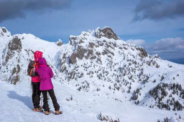 Kışın Ciucas Dağları, Romen Karpatlar. Karla dolu firavun ağaçları ve ardıçlar. Görüntüde yürüyüşçüler var..