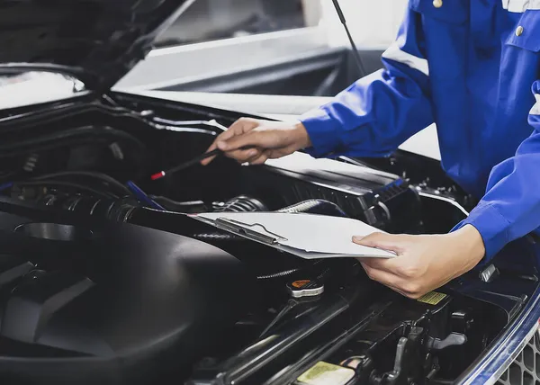 Tamirci garajdaki arabanın motoru üzerinde çalışıyor. Tamir servisi. araba tamir hizmeti konsepti .
