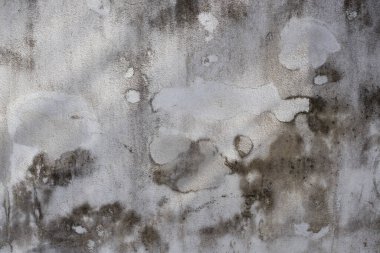 Yüzeyinde çatlaklar olan eski gri beton duvar..